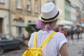 Portrait of girl in hat with trendy purple lilac hair, back view