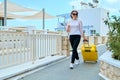 Outdoor portrait of tourist woman with suitcase at hotel sea spa resort, copy space Royalty Free Stock Photo