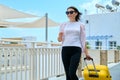 Outdoor portrait of tourist woman with suitcase at hotel sea spa resort, copy space Royalty Free Stock Photo