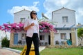 Outdoor portrait of tourist woman with suitcase at hotel sea spa resort, copy space Royalty Free Stock Photo