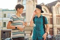 Outdoor portrait of two friends boys teenagers 13, 14 years old talking and laughing on city street Royalty Free Stock Photo
