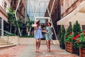 Outdoor portrait of two young beautiful women walking on city street. Best friends hanging, having fun