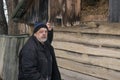 Portrait of Ukrainian old man standing near his barn with hay and looking with hope