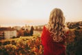 Outdoor portrait of woman with blond curly hair admiring sunset