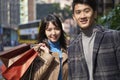 Outdoor portrait of young asian couple holding shopping bags Royalty Free Stock Photo