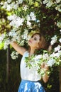 Outdoor portrait of young attractive woman in garden of blooming apple trees. Woman's Day. Female spring concept. Royalty Free Stock Photo