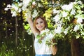 Outdoor portrait of young attractive woman in garden of blooming apple trees. Woman's Day. Female spring concept. Royalty Free Stock Photo