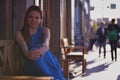 Outdoor portrait of young beautiful caucasian sits on bench on street in St.Petersburg, Russia