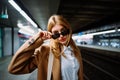 Outdoor portrait of a young beautiful confident woman posing The train station on the background Royalty Free Stock Photo