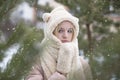 Outdoor portrait of a young beautiful haired girl in a hat posing in winter