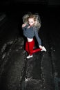 Outdoor portrait of young beautiful happy blond european lady posing on street at night. Model wearing stylish clothes red pants a Royalty Free Stock Photo