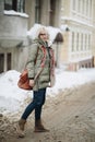 Outdoor portrait of young beautiful happy girl posing on street. Model wearing stylish warm clothes. Magic snowfall. Winter holida Royalty Free Stock Photo