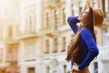 Outdoor portrait of a young beautiful happy smiling woman posing on the street. Model wearing stylish hat and clothes Royalty Free Stock Photo