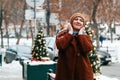 Outdoor portrait of young beautiful happy smiling woman posing on street. winter holidays concept