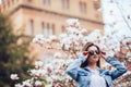 Outdoor portrait of a young beautiful woman near magnolia tree with flowers. Royalty Free Stock Photo