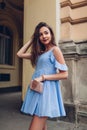 Outdoor portrait of young beautiful woman wearing stylish spring outfit and holding purse. Fashion, beauty model Royalty Free Stock Photo