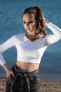 Outdoor portrait of a young beautiful woman who walks along the sea coast and basks in the sunset