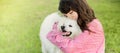 outdoor portrait of young caucasian girl with her pet dog, child owner with white fluffy japanese spitz puppy Royalty Free Stock Photo