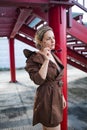 Outdoor portrait of a young elegant fashion woman in trendy sunglasses, camel coat stands near the stairs Royalty Free Stock Photo