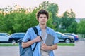 Outdoor portrait of young male college student with backpack, laptop Royalty Free Stock Photo