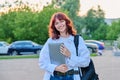 Outdoor portrait of young female college student with backpack, laptop Royalty Free Stock Photo