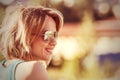 Outdoor portrait of young smiling sunglasses woman