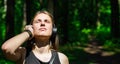 Portrait of young teenager brunette girl with long hair. Happy young woman listening to music with headphones in forest. Royalty Free Stock Photo