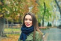 Outdoor portrait of young woman in autumnal city