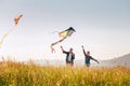 Outdoor portraits of a girl with father while they running with colorful kites by the high grass meadow sincerely laughing. Warm