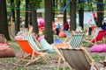 Outdoor Recreation Area with a many colorful soft chair bags, wooden tables and striped folding wooden chairs in a park.
