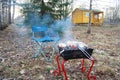 Outdoor recreation. Folding chair and barbecue. Food cooked over a fire.