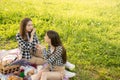 Outdoor recreation. Two cute Caucasian girls in a Park in summer on a Sunny day on a picnic have fun, laugh, eat, communicate, Royalty Free Stock Photo