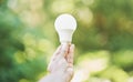 Outdoor, renewable energy and hand with light bulb, green and power development for positive impact. Holding bulb, eco Royalty Free Stock Photo