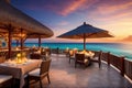 Outdoor restaurant at the beach. Table setting at tropical beach restaurant. beautiful sunset sky, sea view. Luxury Royalty Free Stock Photo