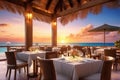 Outdoor restaurant at the beach. Table setting at tropical beach restaurant. beautiful sunset sky, sea view. Luxury Royalty Free Stock Photo