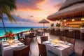 Outdoor restaurant at the beach. Table setting at tropical beach restaurant. beautiful sunset sky, sea view. Luxury Royalty Free Stock Photo