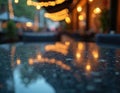 Outdoor restaurant table with blurred string lights bokeh reflection. Empty seats suggest waiting for guests at this cozy eatery Royalty Free Stock Photo