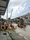 Outdoor scene of workers digging and piling concrete pole preparation for 5G cable connection