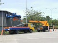 Outdoor scenery in the day with lorry and crane by the road side. Installation advertisement board in progress.