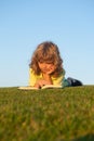 Outdoor school, motivation learning kids. Child boy with a book in the garden. Kid is readding a book playing outdoors