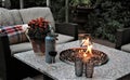 Outdoor seating arrangement around a gas fire pit table in the fall Royalty Free Stock Photo