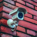 Outdoor security camera mounted on rustic red brick wall Royalty Free Stock Photo