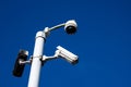 Outdoor security cameras on a metal pole against dark blue sky. Security industry. Government control and surveillance over their