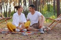 Outdoor shot of beautiful young couple sitting on a plaid in an summer park, looking at each other with love and gentle, Royalty Free Stock Photo