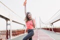 Outdoor shot of blissful girl enjoying victory in marathon. Portrait of laughing happy runner posin