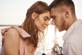 Outdoor shot of cute couple in love, closing eyes and touching with foreheads while sailing on yacht, having vacation Royalty Free Stock Photo