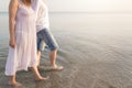 Outdoor shot of romantic young couple walking along the sea shore holding hands Royalty Free Stock Photo