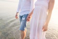 Outdoor shot of romantic young couple walking along the sea shore holding hands Royalty Free Stock Photo