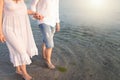Outdoor shot of romantic young couple walking along the sea shore holding hands Royalty Free Stock Photo
