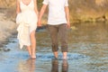 Outdoor shot of romantic young couple walking along the sea shore holding hands Royalty Free Stock Photo